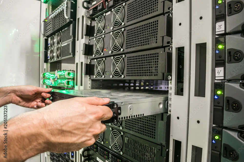 Technician installing rack-mounted equipment inside a data center
