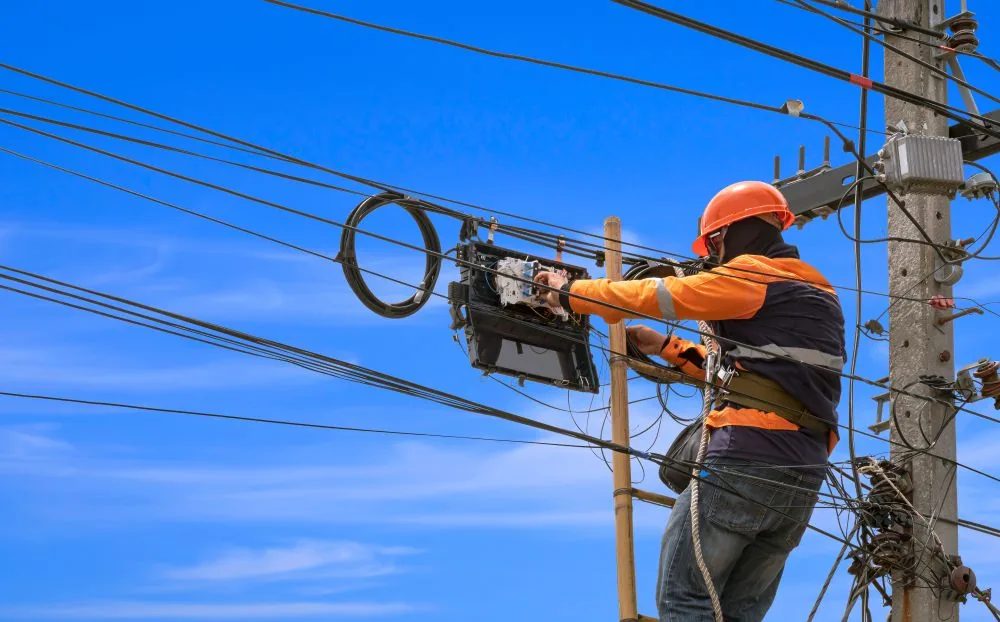 Aerial outside plant telecommunications technician working on overhead fiber infrastructure